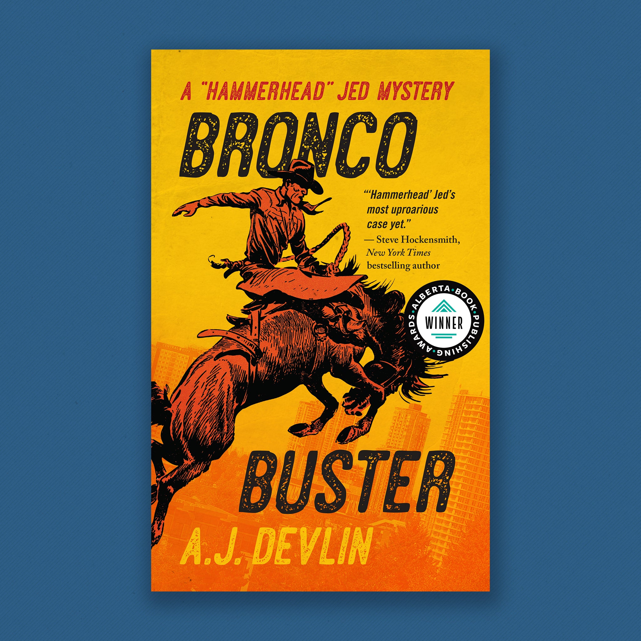 Book Cover: Bronco Buster. A "Hammerhead" Jed Mystery, by A.J. Devlin. On a burnt yellow background, a bucking bronco rises over a city-scape with a cowboy astride it's back. The cowboy is raising his hand into the air to maintain balance. Cover blurb: "Hammerhead Jed's most uprorious case yet." Steve Hockensmith, New York Times bestselling author.